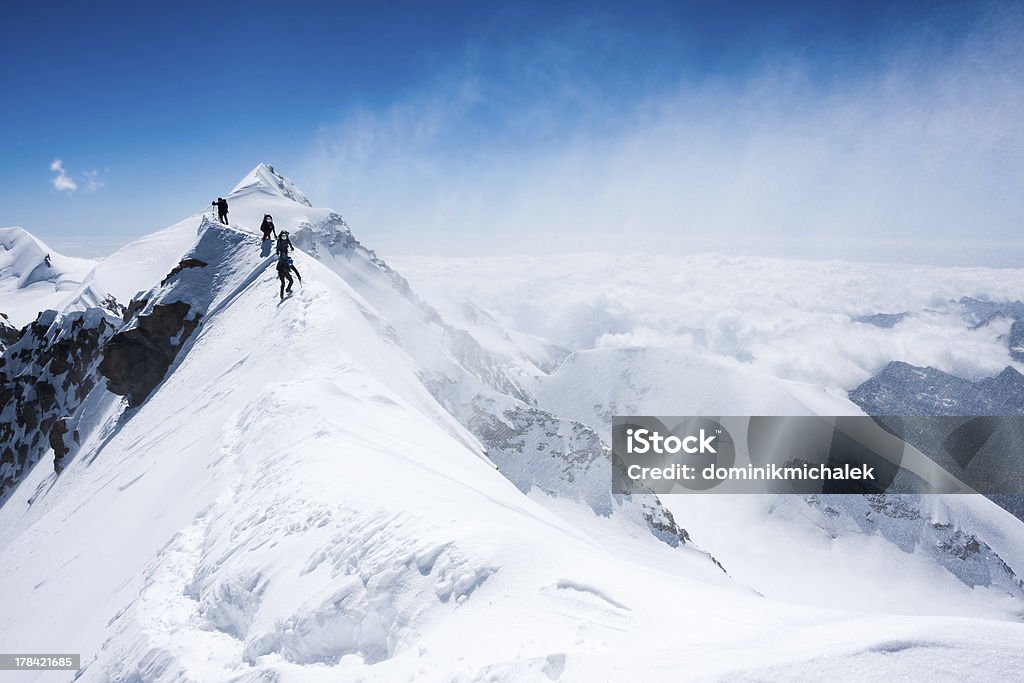 Climber bilanciamento in tempesta su una stretta mountain ridge - Foto stock royalty-free di Alpinismo