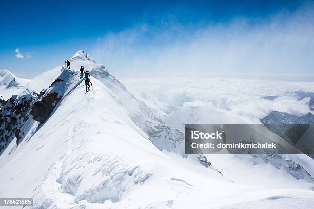 Climbers Balancing In Blizzard On A Narrow Mountain Ridge Stock Photo - Download Image Now