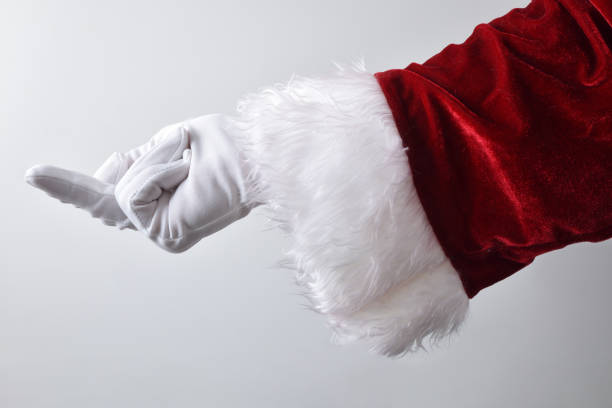 Santa Claus hand rudely showing the middle finger wearing gloves Detail of Santa Claus hand rudely showing the middle finger wearing white gloves traditionally dressed in red isolated with gradient background behind. derogatory stock pictures, royalty-free photos & images