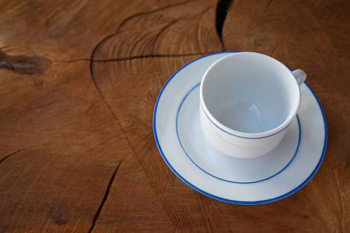 series of 3 empty coffee / tea cups with shallow depth of field on a nice dark oak table                                