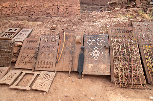 Old Moroccan carved interior wooden doors and wrought iron filigree for window in street trade in Ait Ben Haddou, Morocco