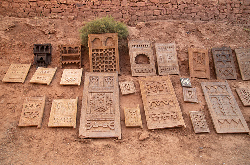 Old Moroccan carved interior wooden doors and pieces of furniture in street trade in Ait Ben Haddou, Morocco