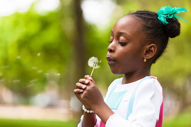 istock Cute young black girl holding a dandelion 178425625