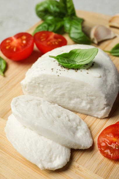 istock Delicious mozzarella with tomatoes and basil leaves on wooden board, closeup 1784257572