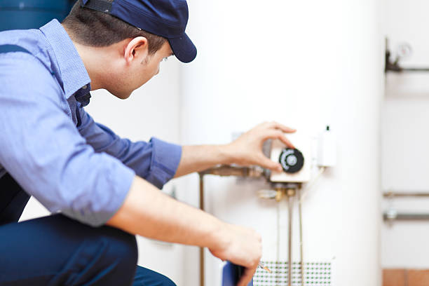 Technician repairing an hot-water heater Smiling technician repairing an hot-water heater boiler photos stock pictures, royalty-free photos & images