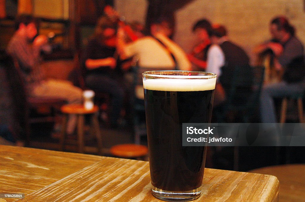 Irish Pub A pint of stout at an Irish Pub, with musician playing in the background Music Stock Photo