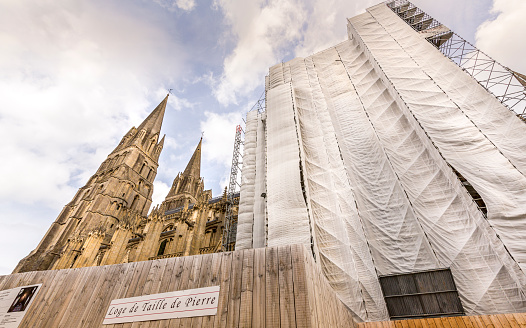 BAYEUX, FRANCE - SEPTEMBER Circa, 2020. Notre Dame cathedral under renovations, covered with the scaffolding.