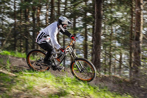 Downhill mountain biker turning at high speed stock photo