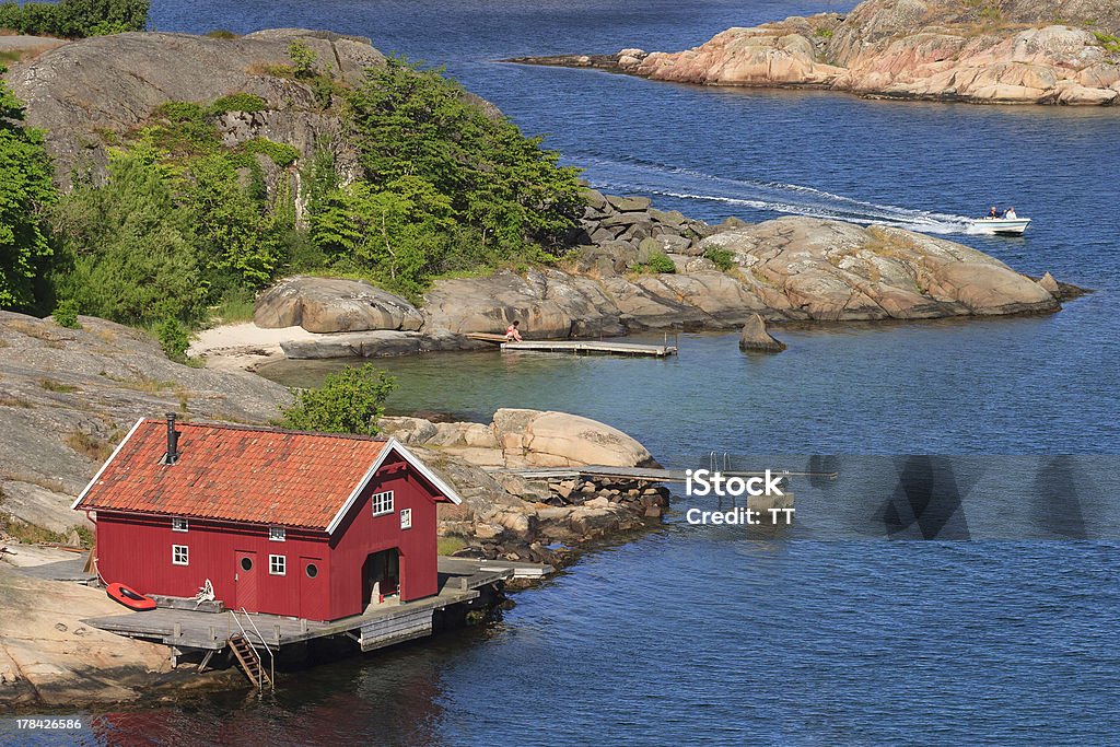 Boathouse Boathouse and a boat on the rocky coast Cliff Stock Photo