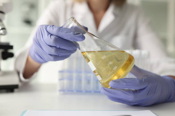 istock Scientist in rubber gloves holds flask with oil in hands 1784266025