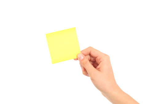 Woman hand holding a yellow notepaper on a white isolated background