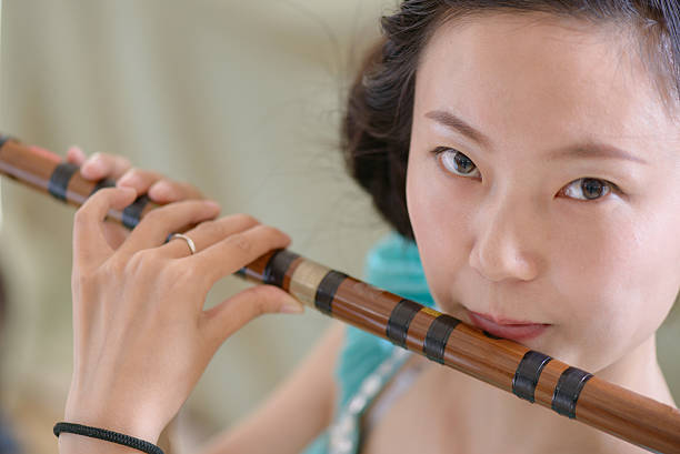istock The girl playing bamboo flute 178426881