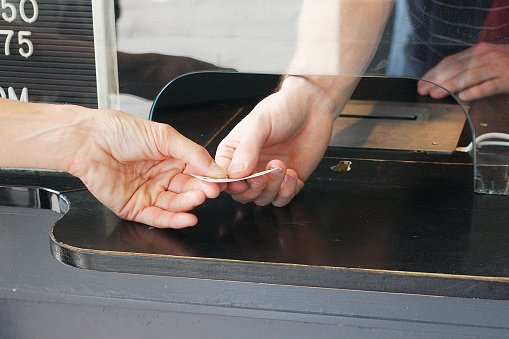 A hand off at a ticket booth.