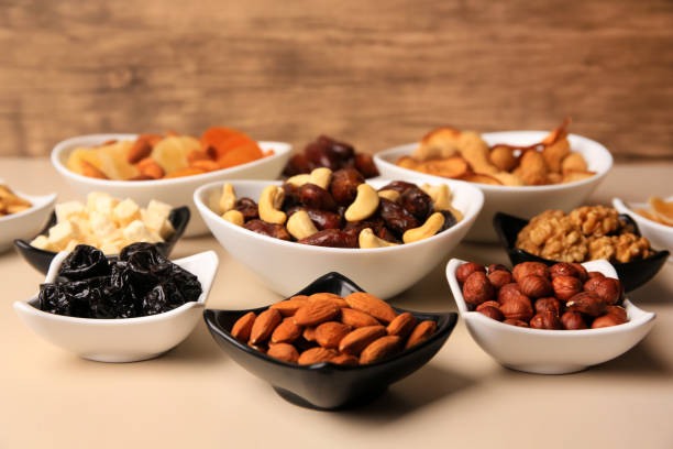 istock Bowls with dried fruits and nuts on beige background 1784273244