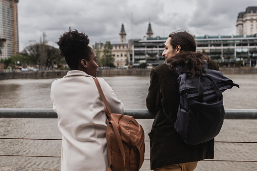 Rear view of young friends talking in Puerto Madero, Buenos Aires