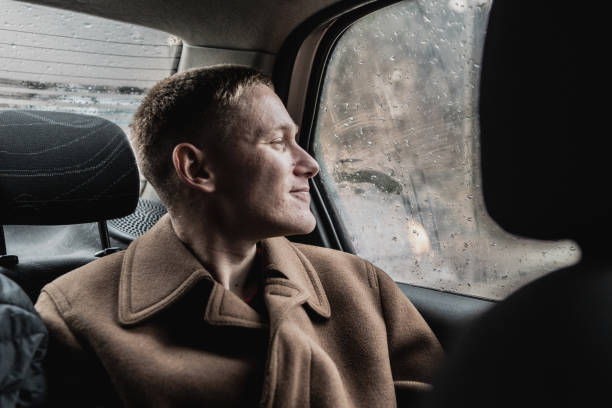 Young man looking through taxi window