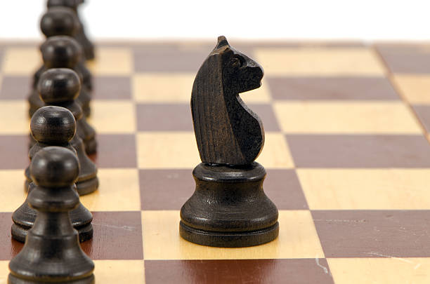 istock Knight stand in front of all pawn chess line board 178427525