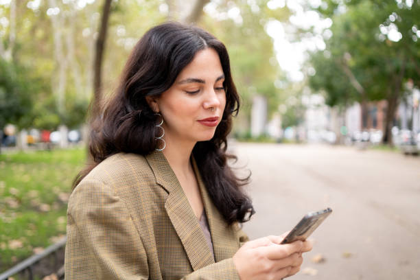 istock Distracted woman using phone in a park bench 1784279426
