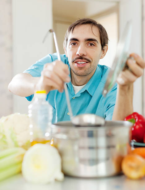 istock guy with ladle cooking vegetables soup at kitchen 178428352