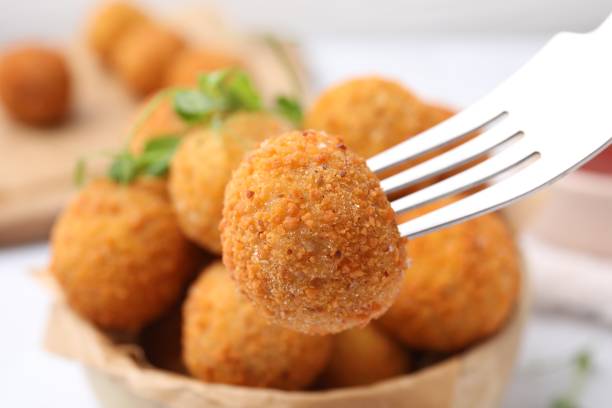istock Taking delicious fried tofu ball with fork from bowl, closeup 1784285414