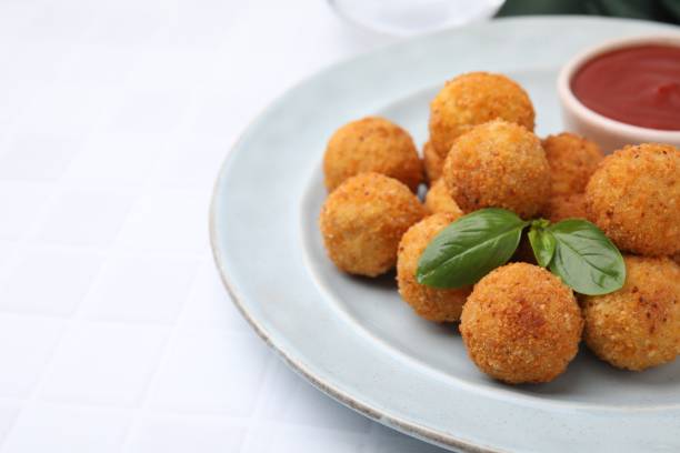 istock Delicious fried tofu balls with basil and ketchup on white tiled table, closeup. Space for text 1784285954