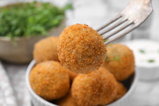 istock Taking delicious fried tofu ball with fork from bowl, closeup 1784287567