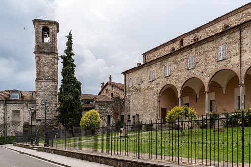 A classic stone building with a grand clock tower in the background, showcasing a timeless architectural style in Italy