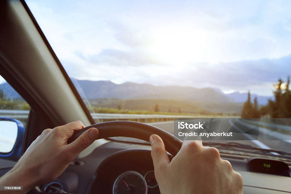 driving Hands of a driver on steering wheel of a car and empty asphalt road Car Stock Photo