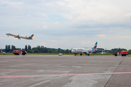 Passenger plane of the German airline Eurowings and AZURAIR Boeing 757-300 UR-AZO. Airport apron. Aircraft and Fire engine on runway. Airplane arrives. Ukraine, Kyiv - September 1, 2021