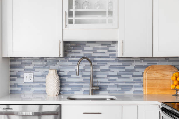 istock A kitchen faucet detal with white cabinets and a blue glass tile backsplash. 1784331805