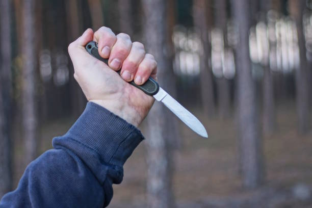 istock a hand holds one old folding army knife on the street 1784331816