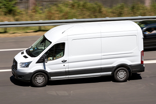 An small work van in motion on a highway