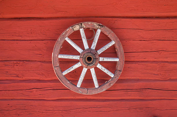 istock Old carriage wheel on a red wall 178433933