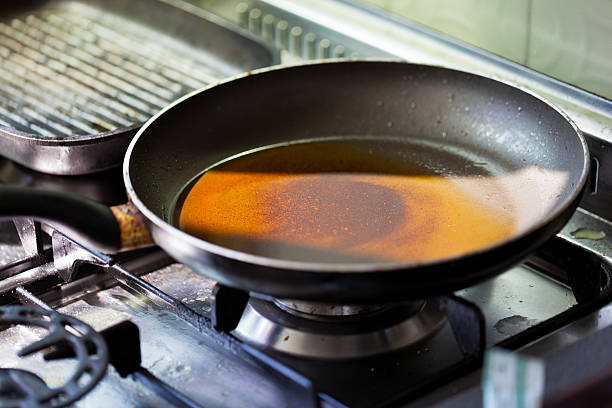 Chef makes flambe in a frying pan causing a big flame