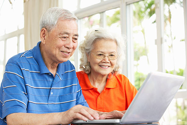 istock Senior Chinese Couple Sitting At Desk Using Laptop 178434774