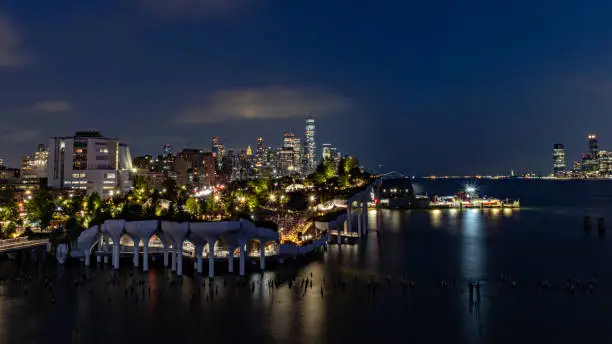 Aerial shot of downtown New York City and the Hudson River lit up at night.