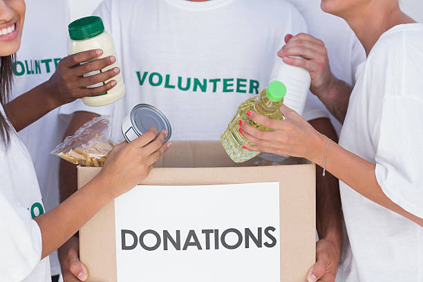 istock Volunteers putting food in donation box 178436087