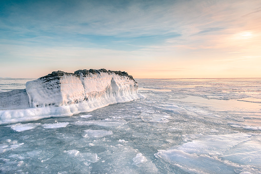 Sea winter landscape. Sea slush and ice floes on the sea surface in winter during sunset. Fabulous winter day by the sea.