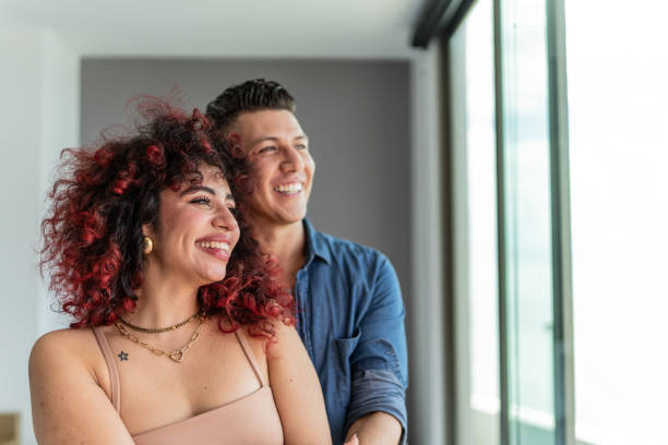 istock Couple embracing and looking at view at hotel room 1784367416