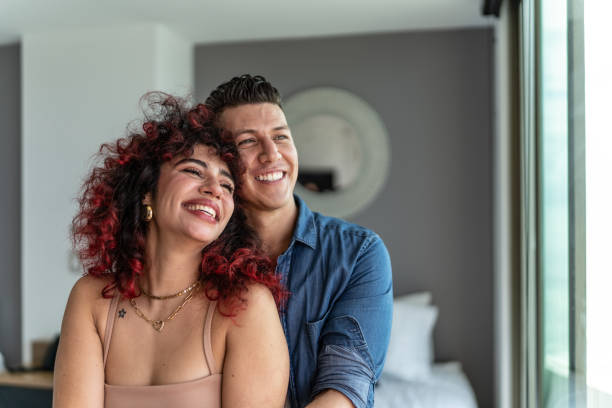 Couple embracing and looking at view at hotel room