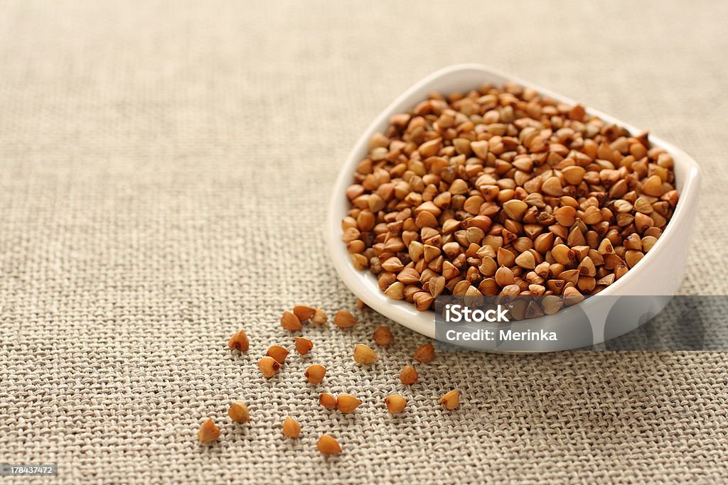 Sarrasin de céréales dans un bol en céramique blanc sur fond sackcloth - Photo de Agriculture libre de droits