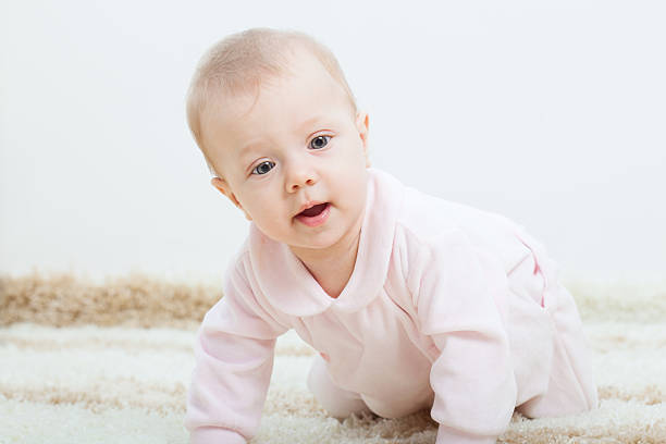 istock baby girl creeping on the carpet 178437929
