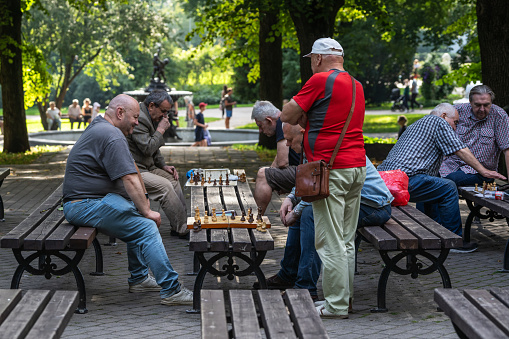 Riga, Latvia - August 20, 2023: Men play chess on the benches in the Vermanes garden park
