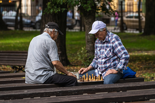 Riga, Latvia - August 20, 2023: Men play chess on the benches in the Vermanes garden park