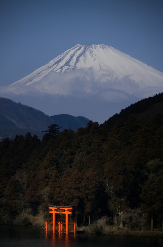 Hakone, Japan - February 28th, 2013: Magnificent Mount Fuji dwarfs a Shinto shrine.