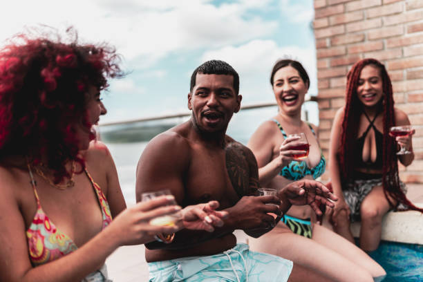 istock Friends talking sitting by the pool at hotel 1784385387