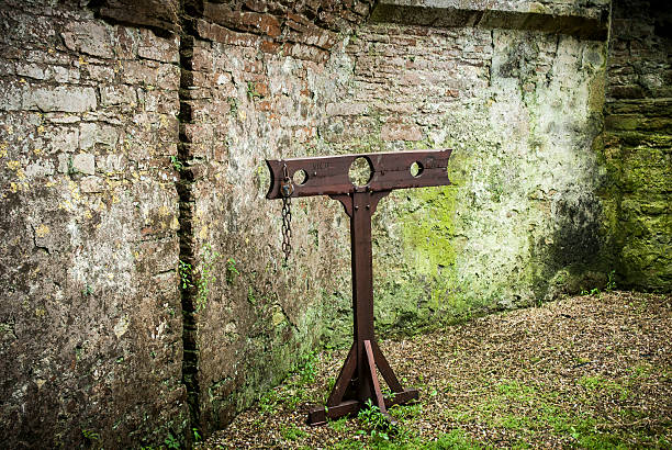 Medieval Stocks Detail of wooden medieval stocks used to incarcerate criminals in castle grounds. dungeon medieval prison prison cell stock pictures, royalty-free photos & images