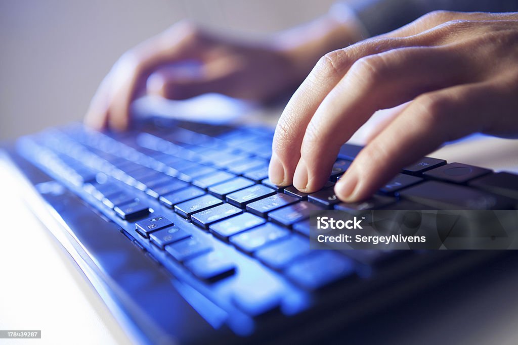 Click! Hands of a man on keyboard Click! Hands of a man on a keyboard with blue backlighting. Business Stock Photo