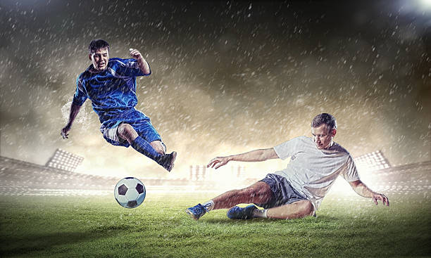 istock two football players striking the ball 178439598