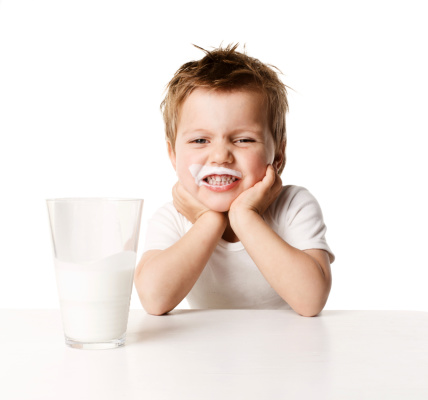 little boy drinking milk and licks her lips, isolation on a white background